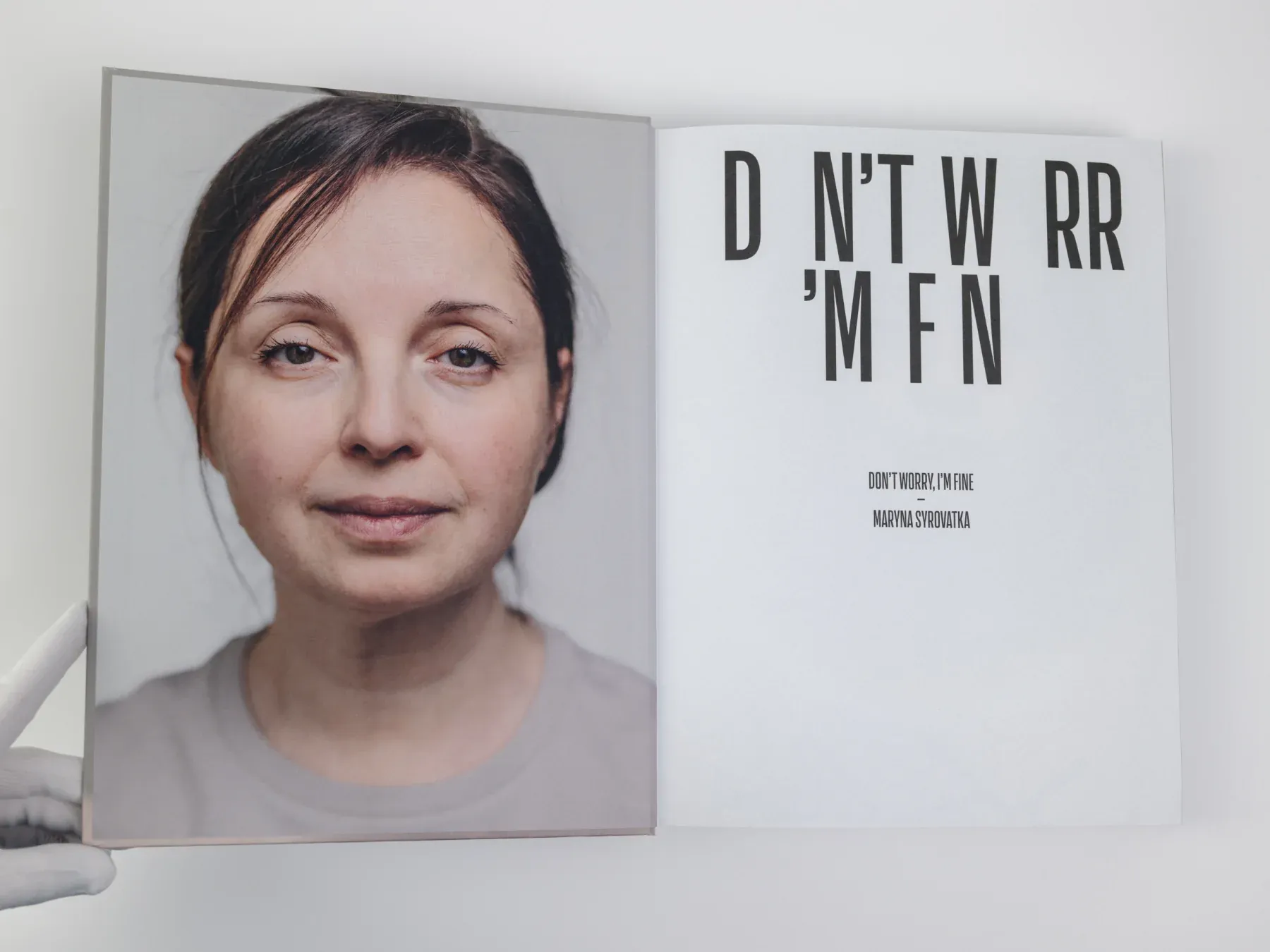 An open copy of Don't Worry, I'm Fine, showing a full-page portrait opposite the book's title page